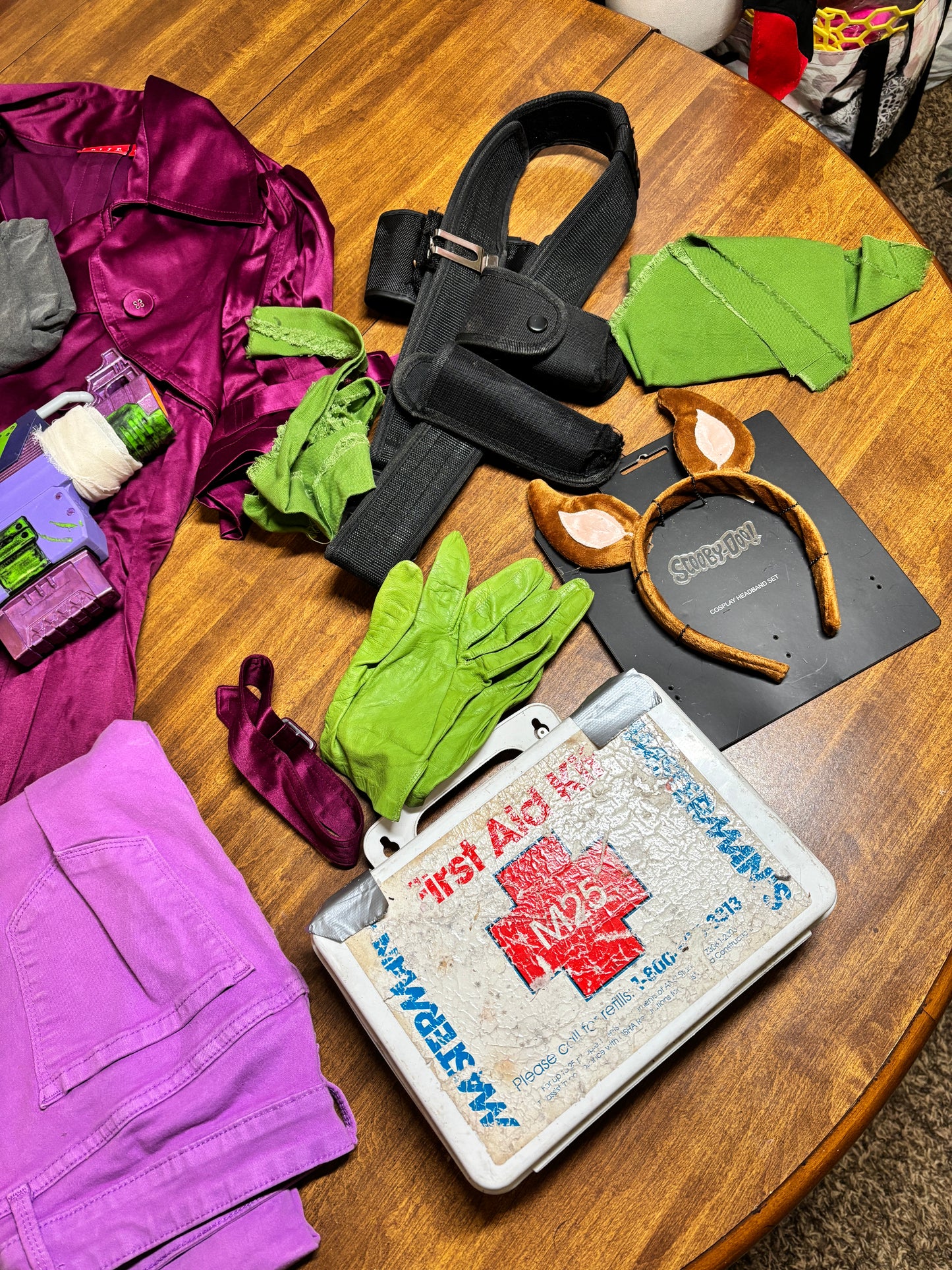 Assorted items including gloves, a jacket, and a box on a wooden surface. Inspired by Daphne from Scooby Doo and the Apocolyptic Comic Book Series.