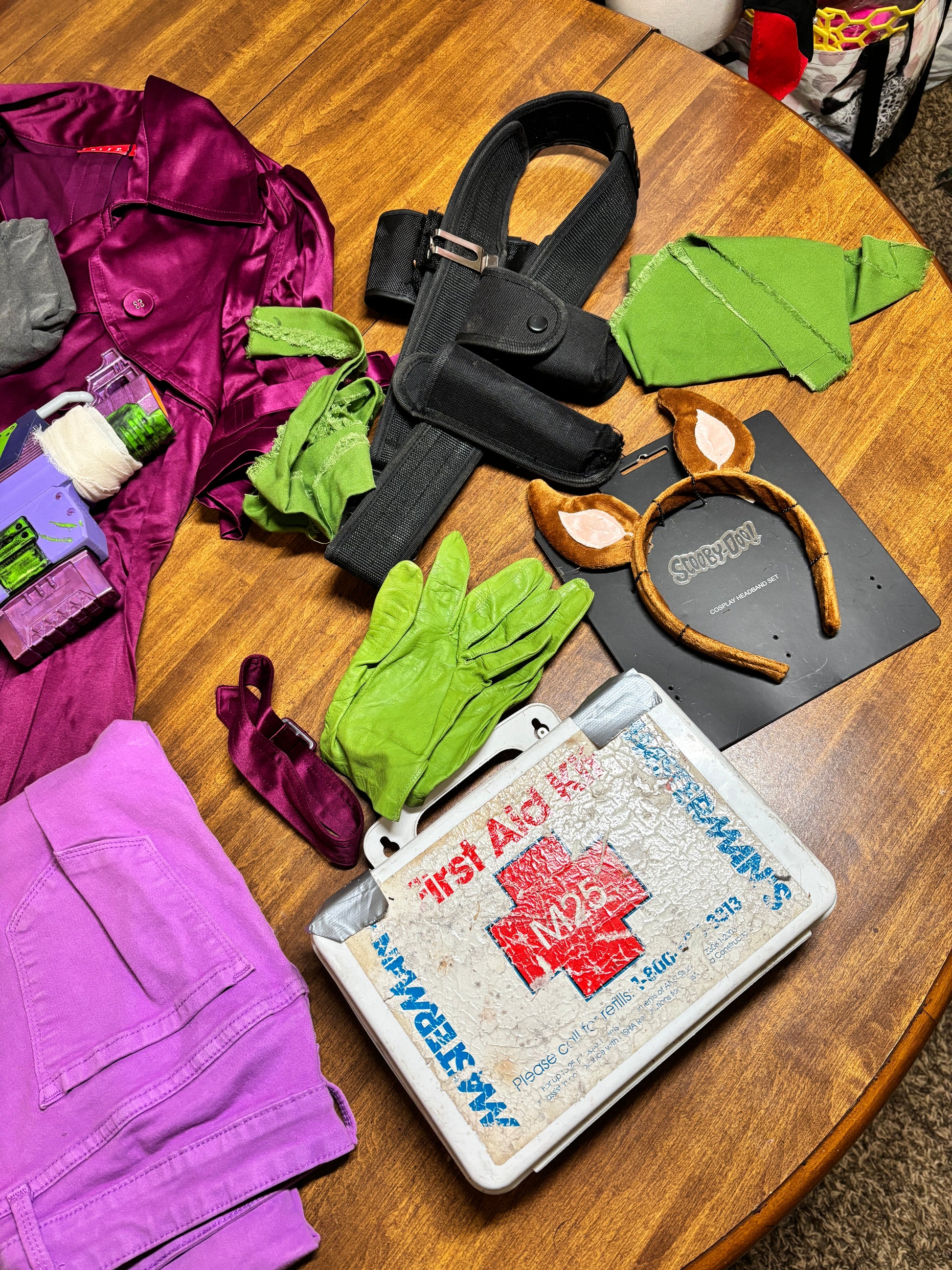 Assorted items including gloves, a jacket, and a box on a wooden surface. Inspired by Daphne from Scooby Doo and the Apocolyptic Comic Book Series.