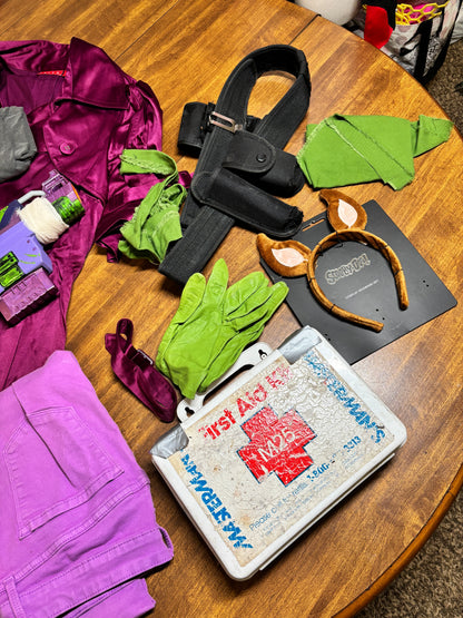 Assorted items including gloves, a jacket, and a box on a wooden surface. Inspired by Daphne from Scooby Doo and the Apocolyptic Comic Book Series.