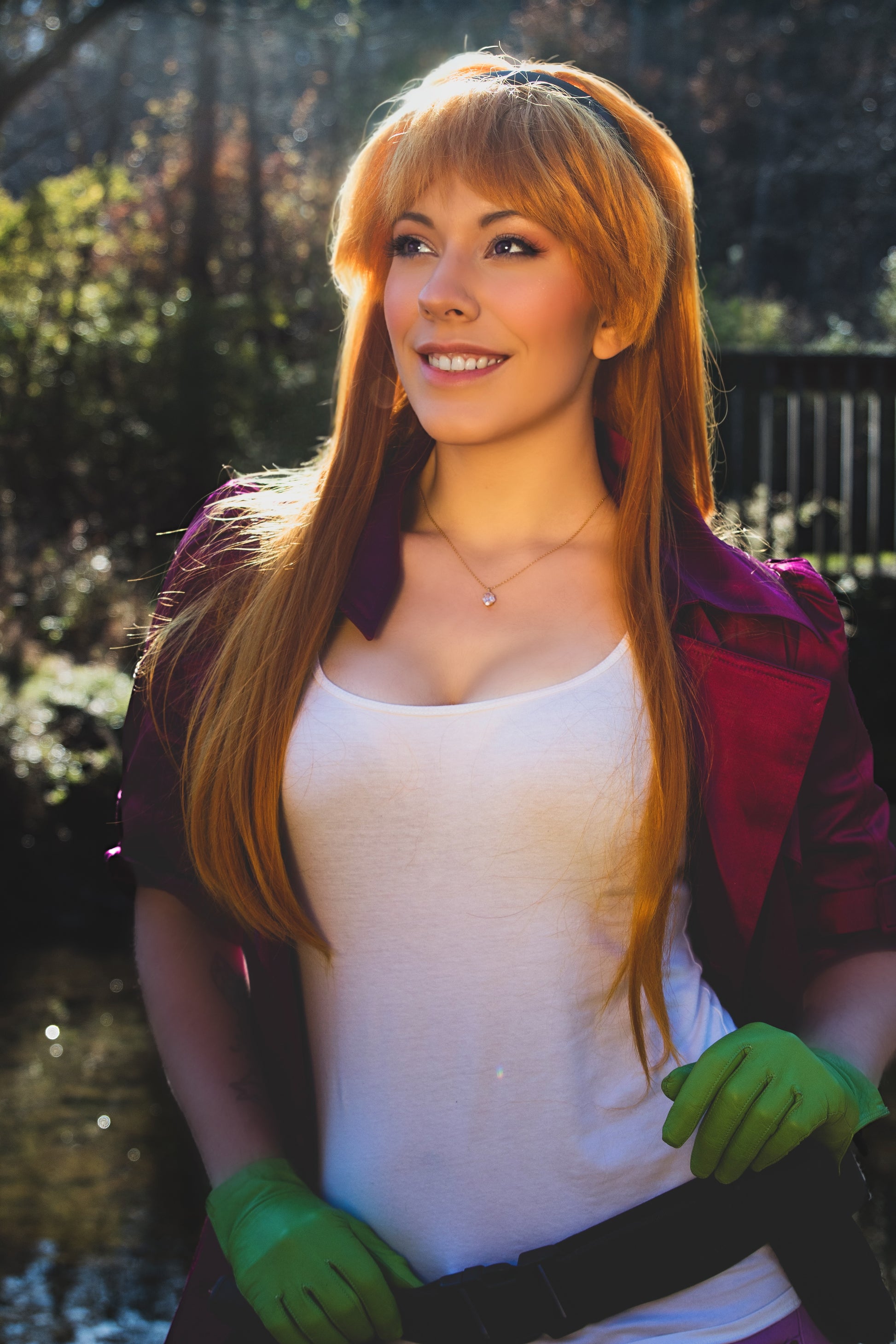 Person with long red hair wearing a white tank top, purple jacket, and green gloves outdoors. Inspired by Daphne from Scooby Doo and the Apocolyptic Comic Book Series.