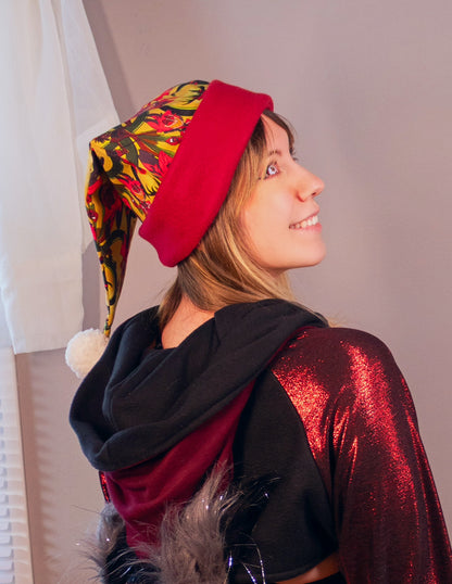 Person wearing a red hat with colorful patterns and a black and red outfit. Print is of Alastor from Hazbin hotel.