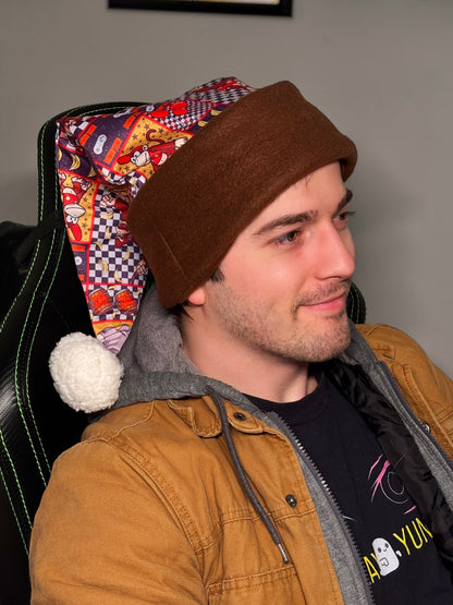 Man wearing a brown beanie and tan jacket sitting on a chair with colorful backrest. Inspired by Donkey Kong