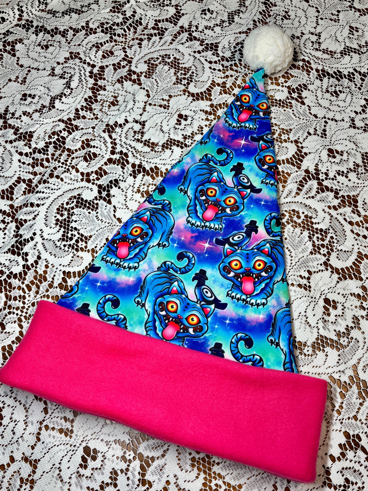 Pink fabric with a blue patterned fabric on top, on a lace background. Pattern is of Deroy Tiger from Kpop Demon Hunters