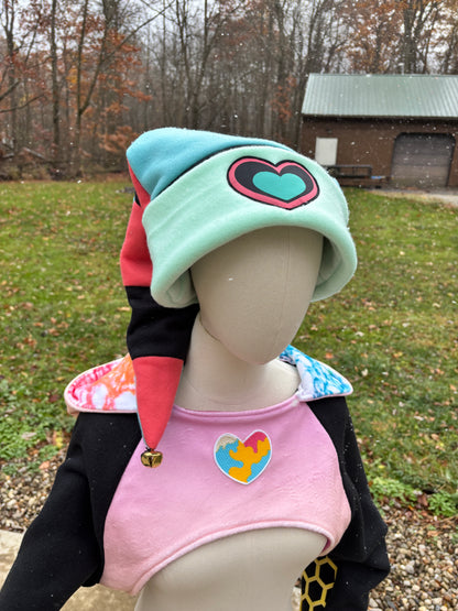 Person wearing a pink vest with a heart design outdoors. Inspired by Fizzarolli from Helluve Boss. 