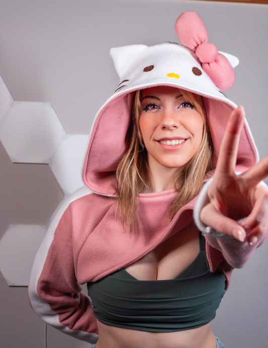Girl wearing a handmade cosplay shrug inspired by Hello Kitty. It is pink and white with Hello Kitty's face and bow on the hood. Cery kawaii cute.