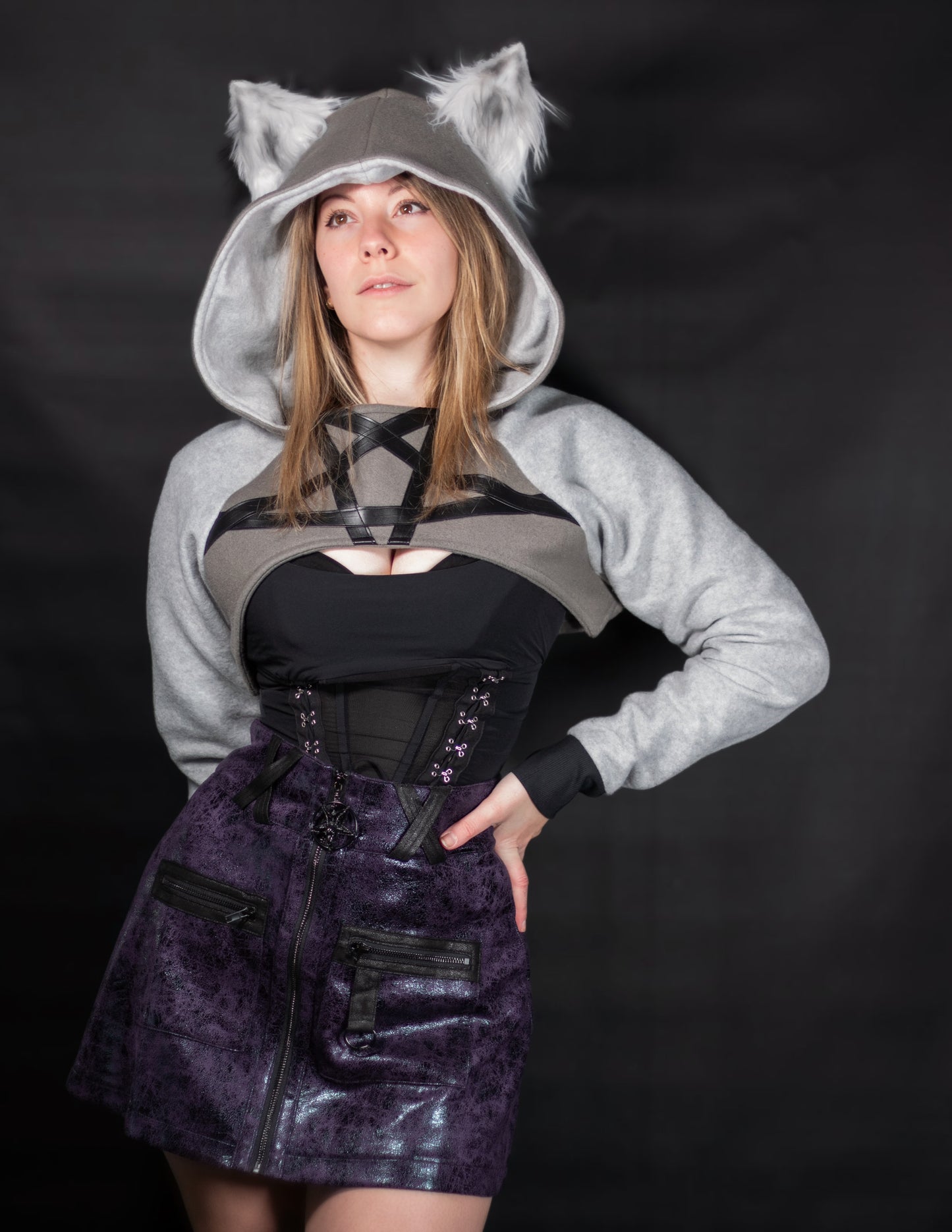 Person wearing a gray hoodie with wolf ears on a black background. Shrug is inspired by Loona from Helluve Boss.