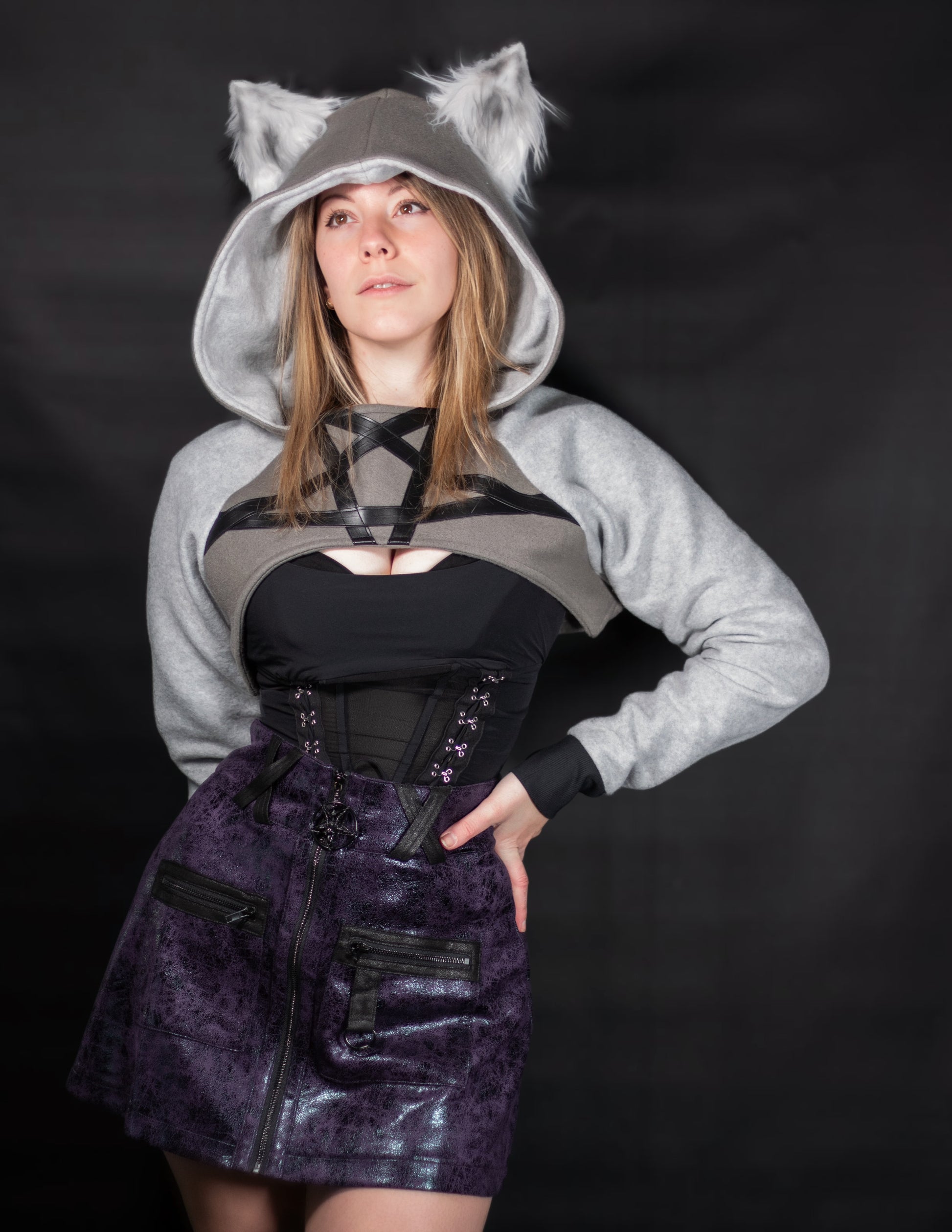 Person wearing a gray hoodie with wolf ears on a black background. Shrug is inspired by Loona from Helluve Boss.