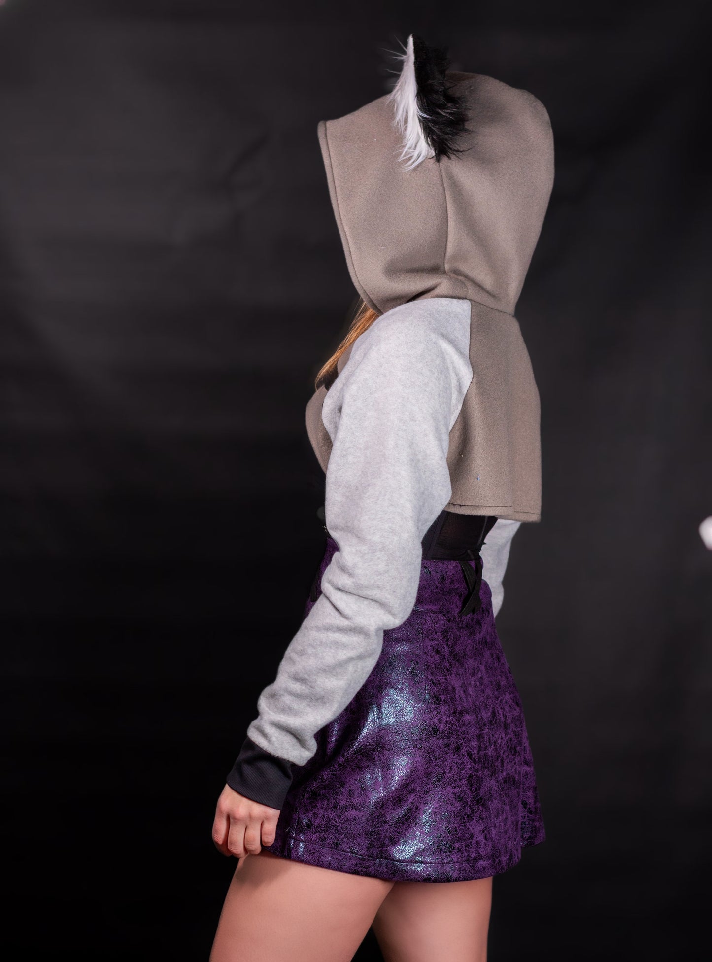 Person wearing a hoodie with wolf ears on a black background. Shrug is inspired by Loona from Helluve Boss. Showing the side veiw and arms