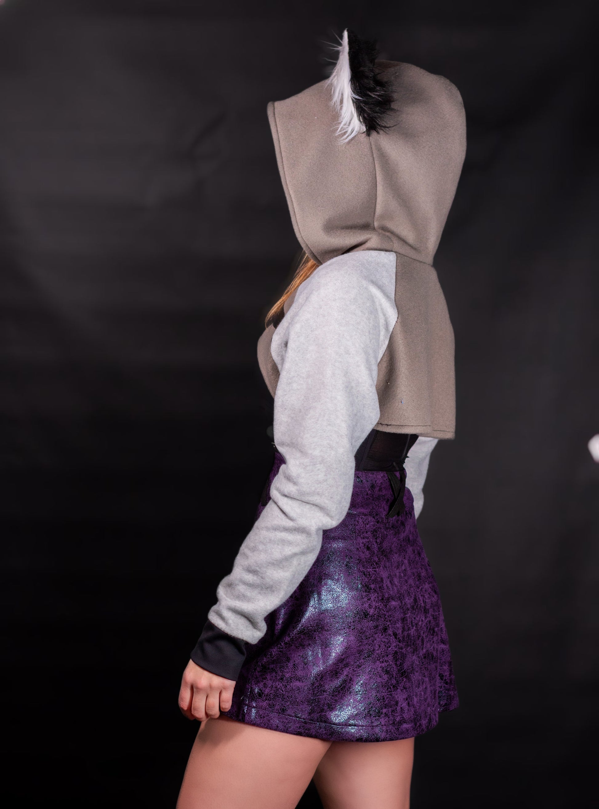Person wearing a hoodie with wolf ears on a black background. Shrug is inspired by Loona from Helluve Boss. Showing the side veiw and arms