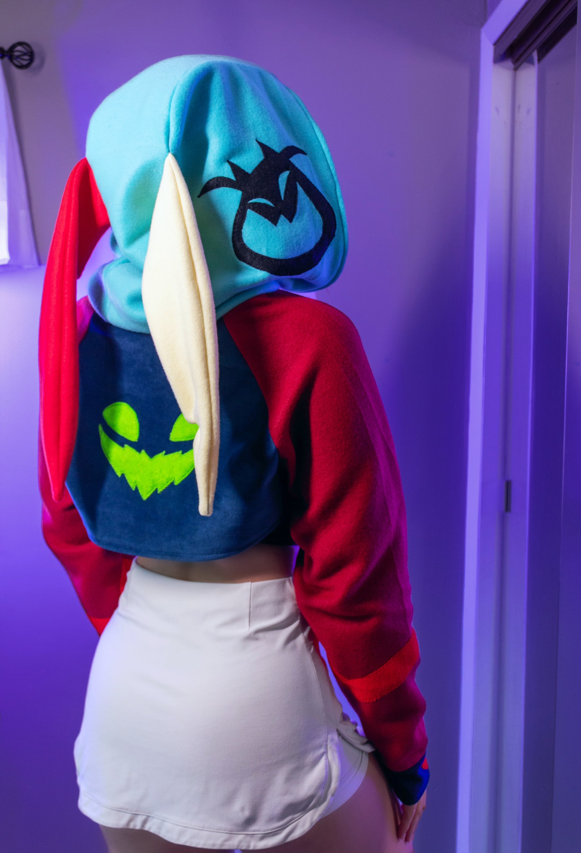 Asmodeus Cosplay cropped hoodie shrug inspired by Helluva Boss shown on a model with a purple background and matching outfit. 