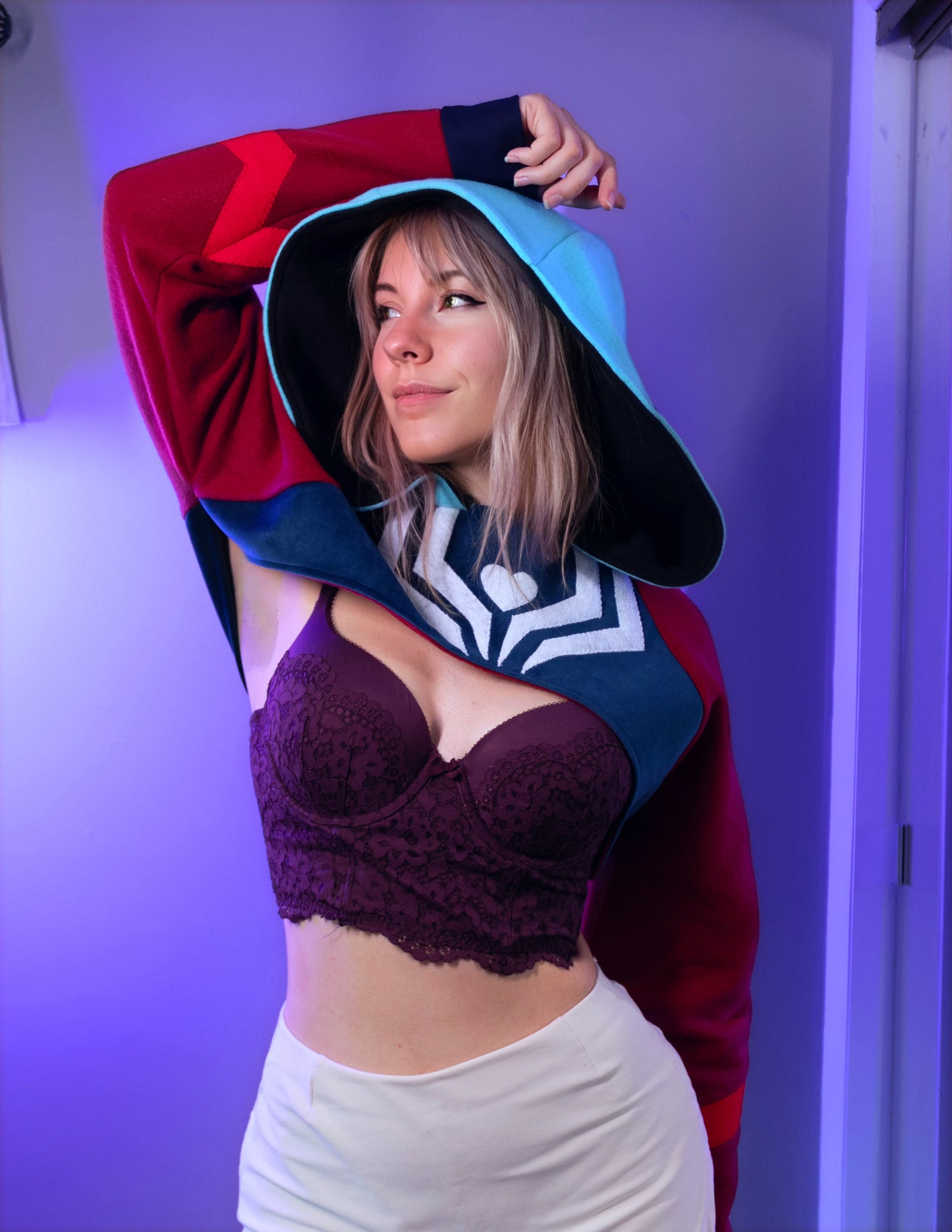 Asmodeus Cosplay cropped hoodie shrug inspired by Helluva Boss shown on a model with a purple background and matching outfit. 