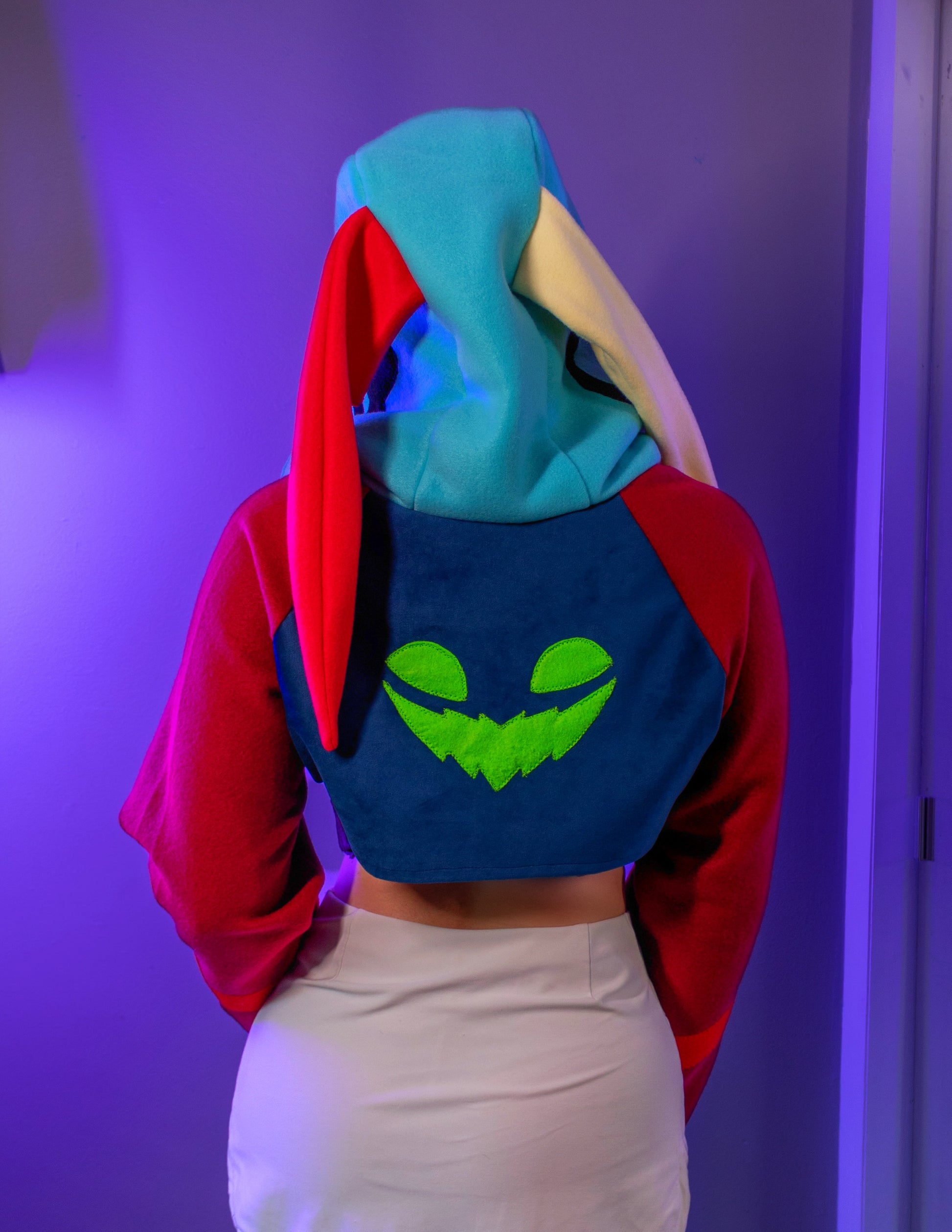 Asmodeus Cosplay cropped hoodie shrug inspired by Helluva Boss shown on a model with a purple background and matching outfit. 