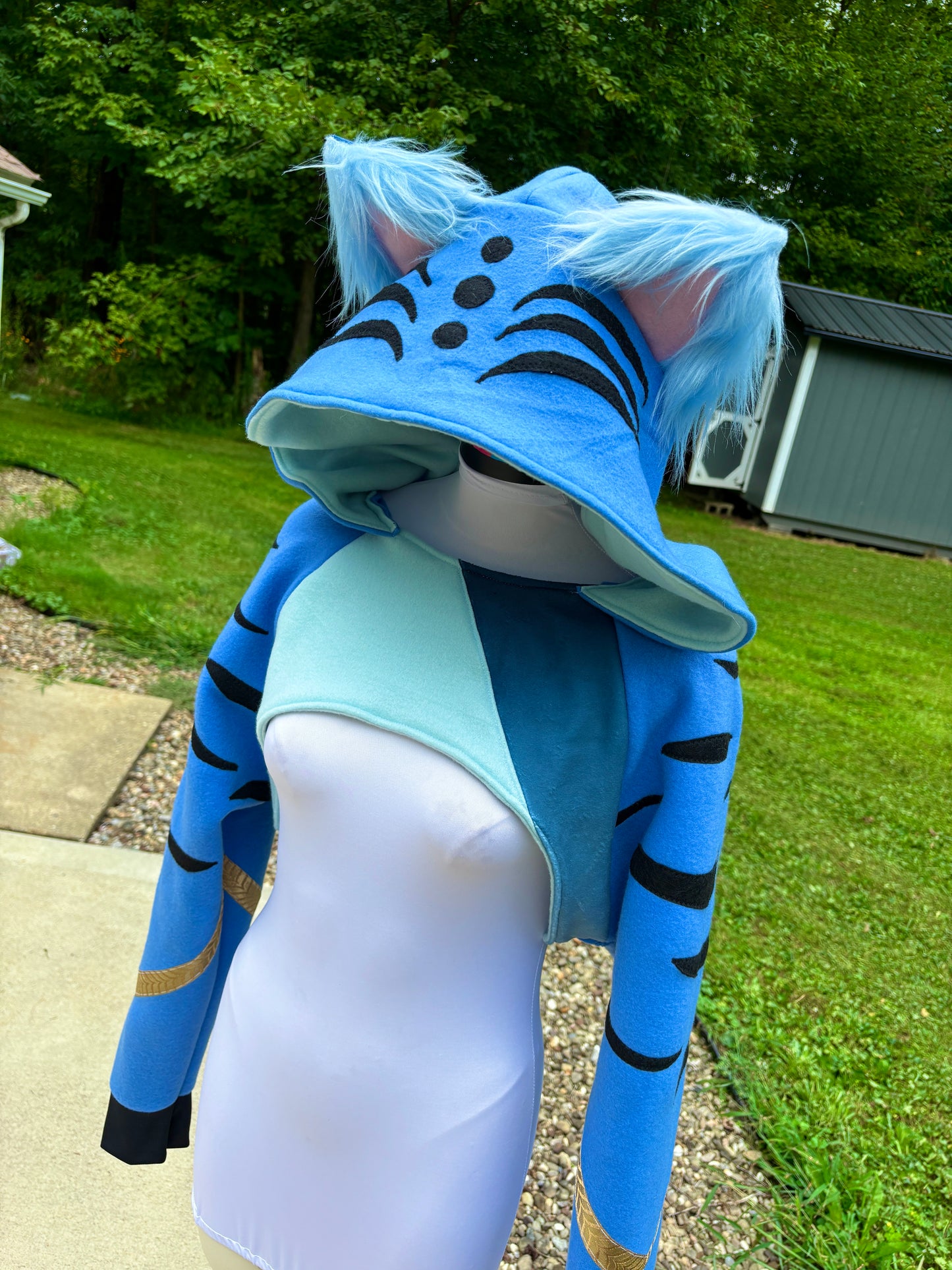  a cosplay shrug inspired by Derpy Tiger from Kpop Demon Hunters. It is different shade of blue with  character designs