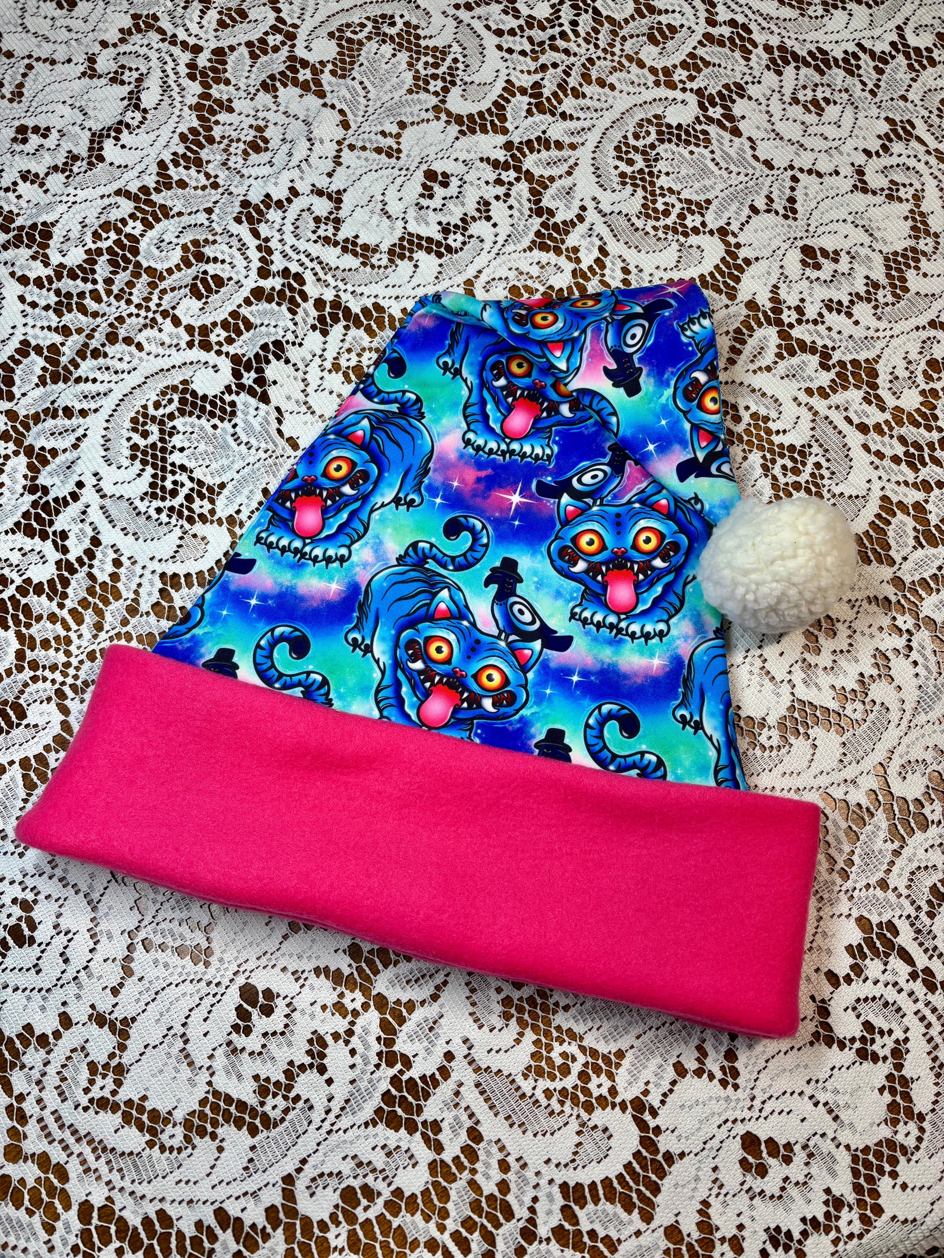 Pink fabric with a blue patterned fabric on top, on a lace background. Pattern is of Deroy Tiger from Kpop Demon Hunters