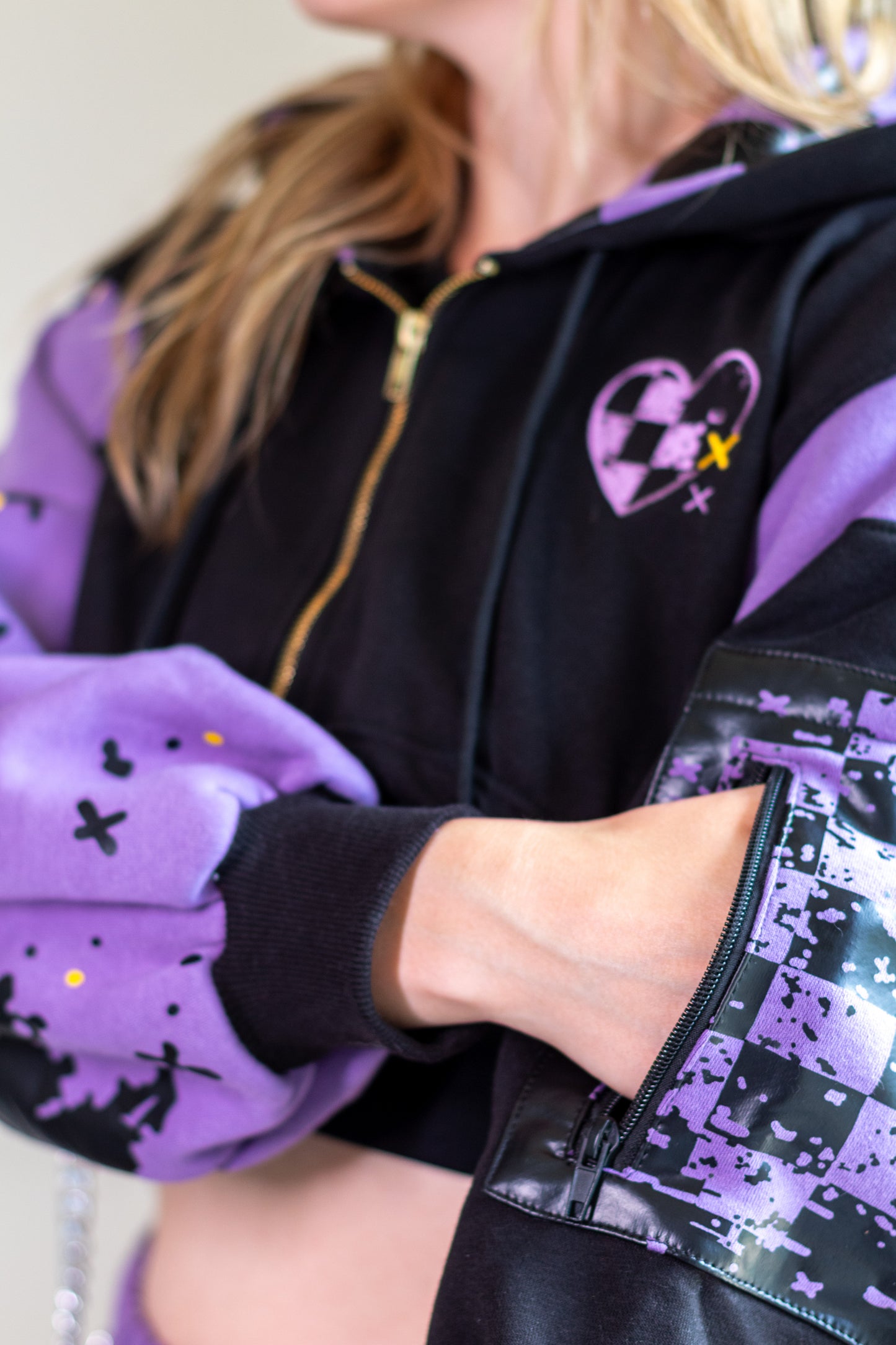Person wearing a black and purple jacket with a heart design. Showing the pocket detail.  Inspired by Jax from The Amazing Digital Circus TADC