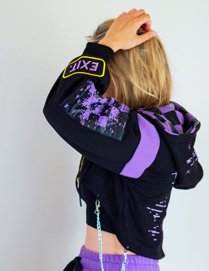 Person wearing a black and purple hoodie with digital design on sleeves against a white background.  Inspired by Jax from The Amazing Digital Circus TADC