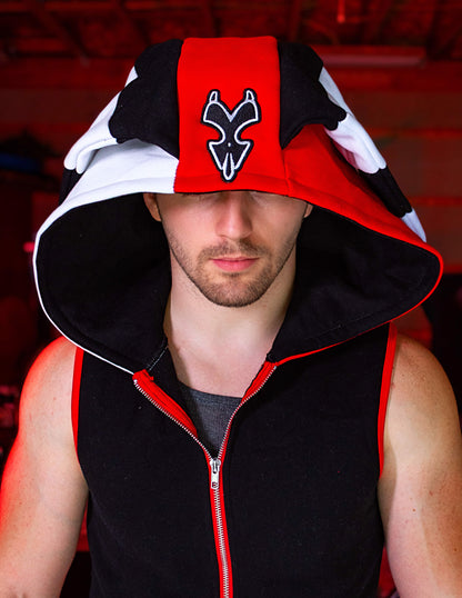 Person wearing a black, red, and white hoodie with a logo on a blurred background. Blitz cosplay inspired by Helluva Boss. sleevelss hoodie
